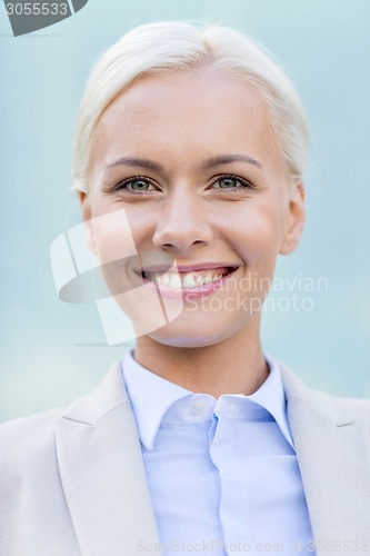 Image of young smiling businesswoman over office building