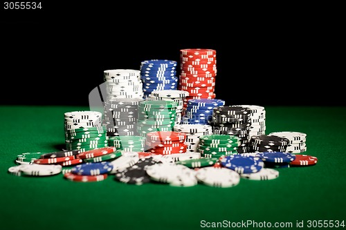 Image of close up of casino chips on green table surface