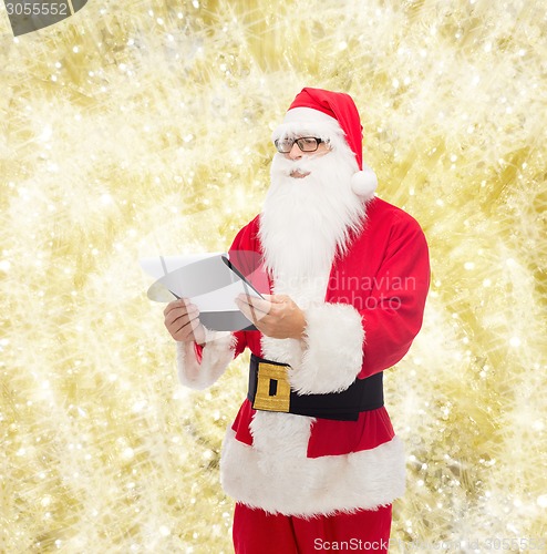 Image of man in costume of santa claus with notepad