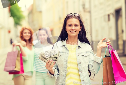 Image of smiling teenage girls with shopping bags on street