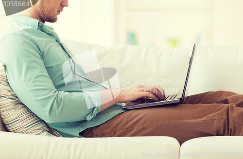 Image of close up of man working with laptop at home