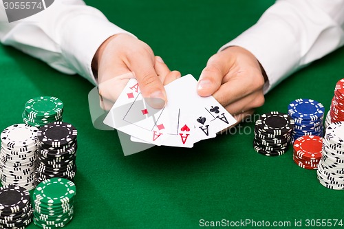 Image of poker player with cards and chips at casino