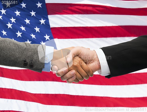 Image of close up of handshake over american flag