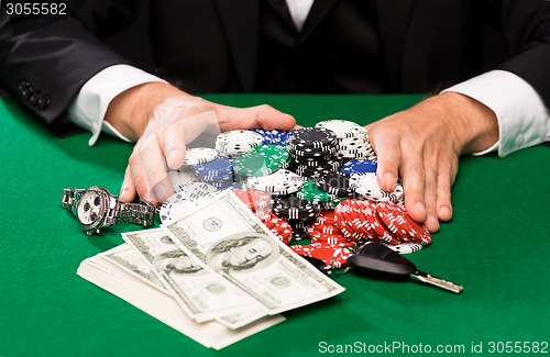 Image of poker player with chips and money at casino table