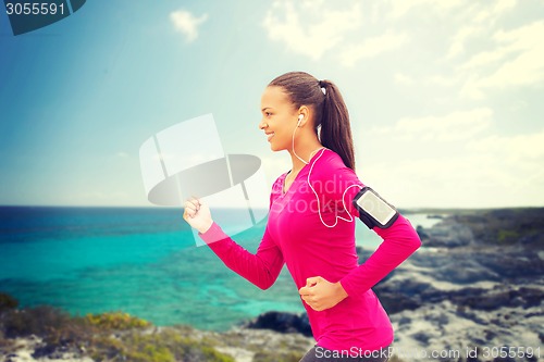 Image of smiling young woman running outdoors