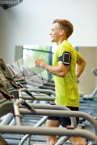 Image of smiling man exercising on treadmill in gym