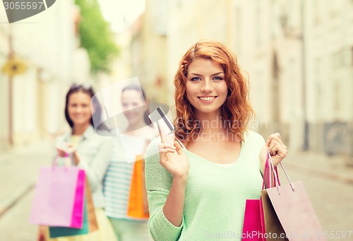 Image of smiling teenage girls with shopping bags on street