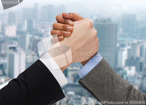 Image of hands of two people arm wrestling