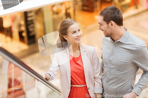 Image of happy young couple with shopping bags in mall