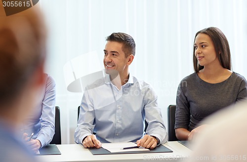 Image of group of smiling businesspeople meeting in office