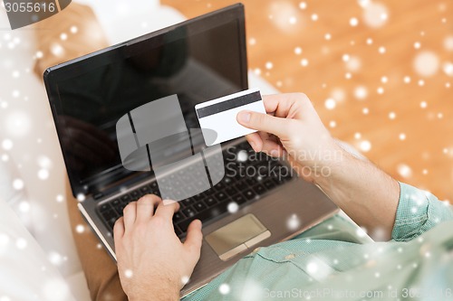 Image of close up of man with laptop and credit card