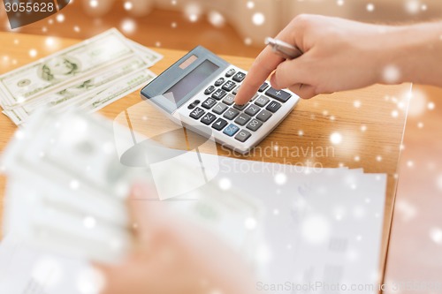 Image of close up of man counting money and making notes