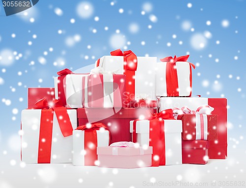 Image of christmas presents over blue background with snow