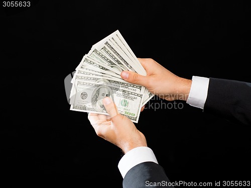 Image of close up of male hands holding dollar cash money