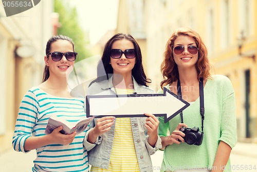 Image of smiling teenage girls with white arrow outdoors