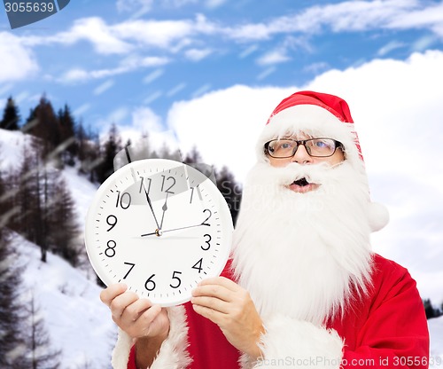 Image of man in costume of santa claus with clock