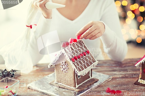 Image of close up of woman making gingerbread houses