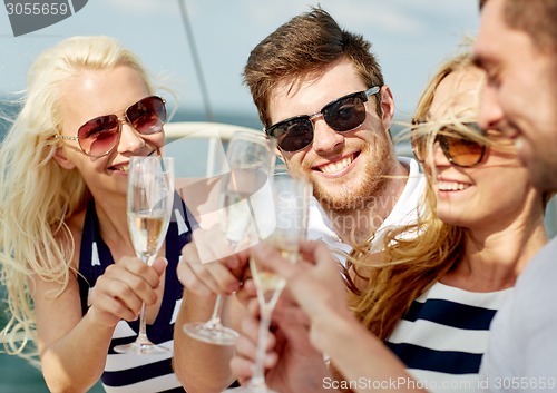 Image of smiling friends with glasses of champagne on yacht