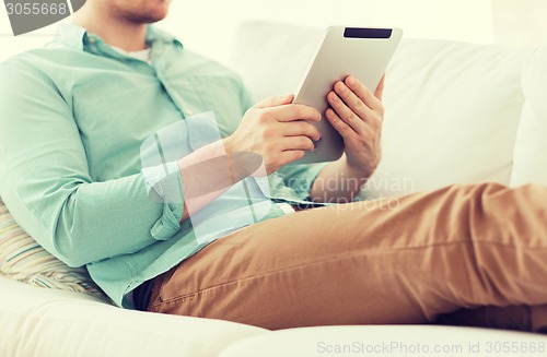 Image of close up of man with tablet pc computer at home