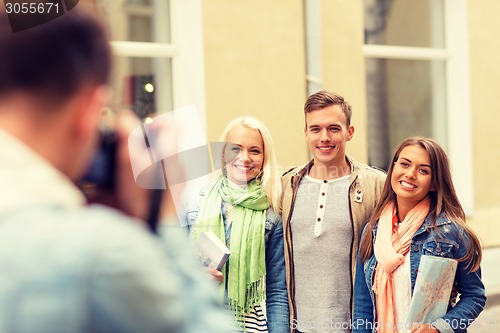 Image of group of smiling friends taking photo outdoors