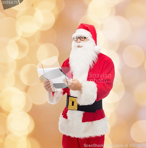 Image of man in costume of santa claus with notepad