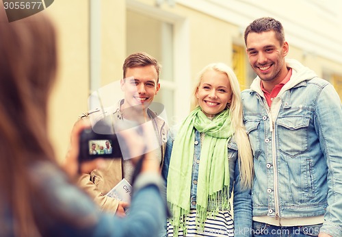 Image of group of smiling friends taking photo outdoors