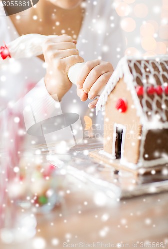 Image of close up of woman making gingerbread house at home