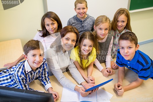 Image of group of kids with teacher and tablet pc at school