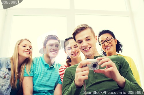 Image of smiling students with digital camera at school