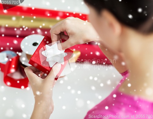 Image of close up of woman decorating christmas present