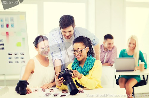 Image of smiling team with photocamera working in office