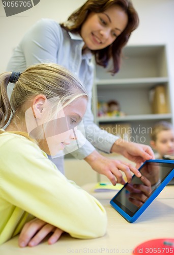 Image of little girl with teacher and tablet pc at school