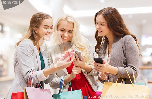 Image of happy women with smartphones and shopping bags