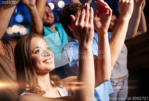 Image of smiling friends at concert in club