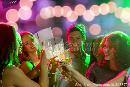 Image of smiling friends with glasses of champagne in club