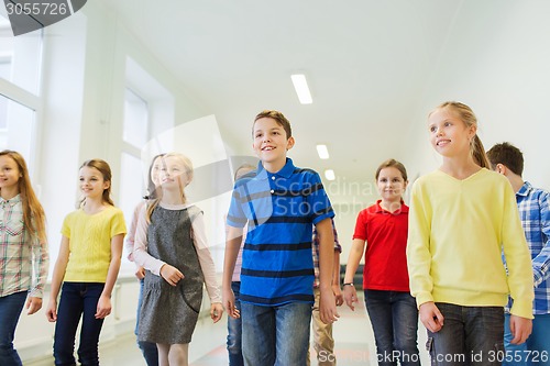 Image of group of smiling school kids walking in corridor