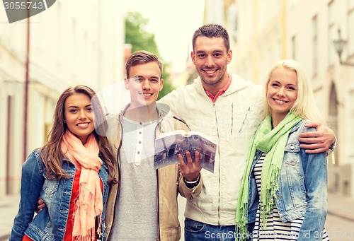 Image of group of friends with city guide exploring town