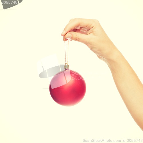 Image of close up of woman in sweater with christmas ball
