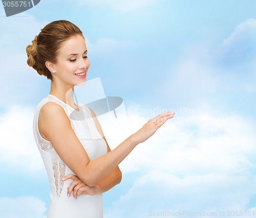 Image of smiling woman in white dress with diamond ring