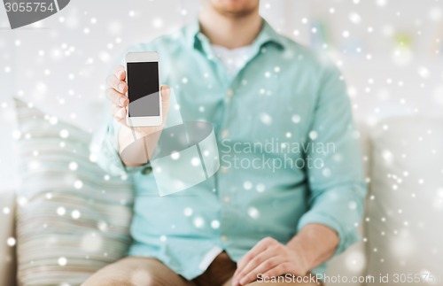Image of close up of man showing smartphone at home