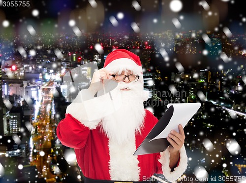 Image of man in costume of santa claus with notepad