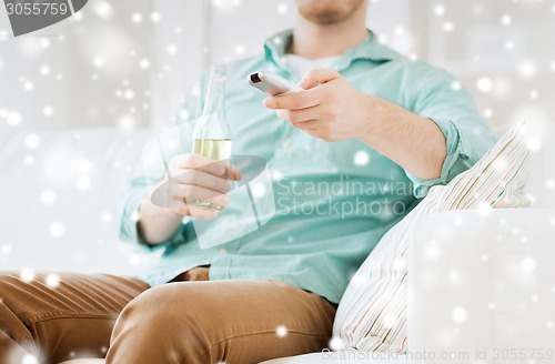 Image of man with beer and remote control at home