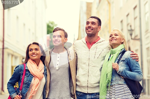 Image of group of smiling friends walking in the city