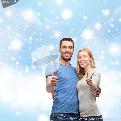 Image of happy couple showing thumbs up and hugging