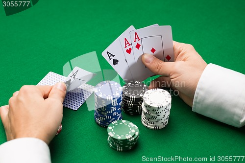 Image of poker player with cards and chips at casino