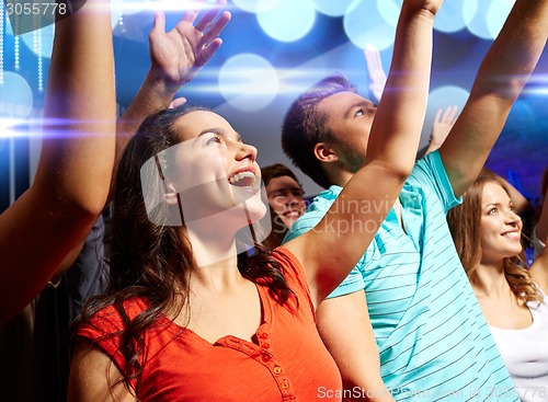 Image of smiling friends at concert in club