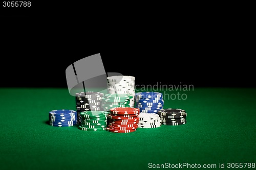 Image of close up of casino chips on green table surface