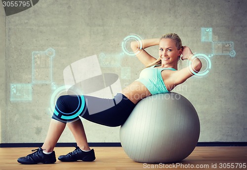 Image of smiling woman with exercise ball in gym