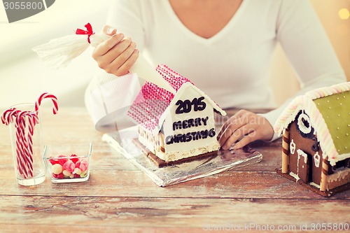 Image of close up of woman making gingerbread houses