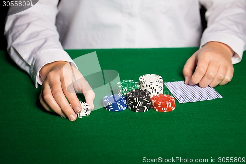 Image of holdem dealer with playing cards and casino chips